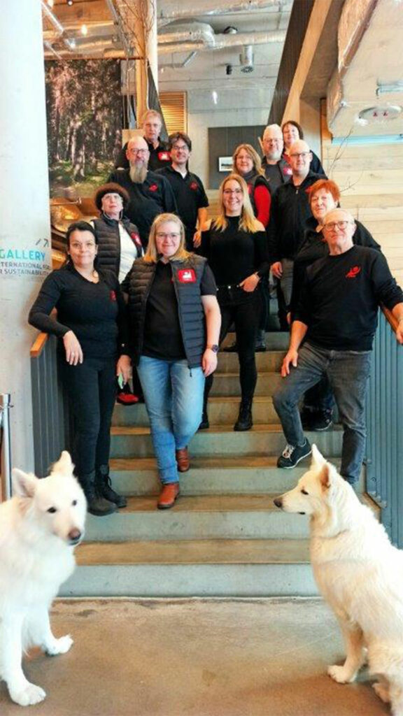Personen stehen auf einer Treppe mit zwei Hunden im Vordergrund